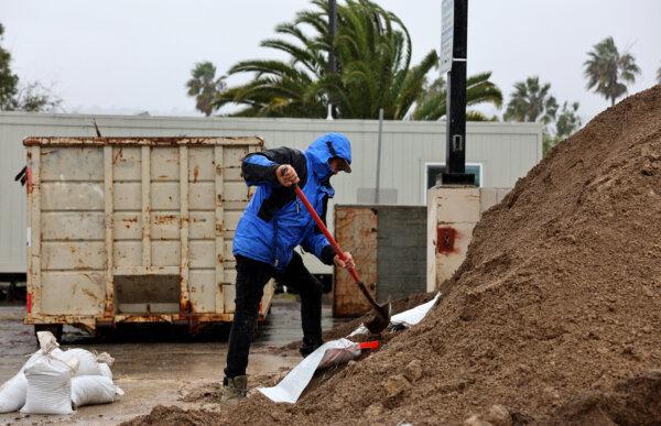 A person shovels at a sandbag station in preparation for flooding as a powerful long-duration atmospheric river storm, the second in less than a week, impacts California in Santa Barbara, Calif., on Feb. 4, 2024. (Mario Tama/Getty Images)
