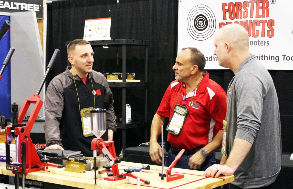 Scott Kempel (R), of Forster Products, talks with other company representatives in the Forster Products booth at the Shooting, Hunting, Outdoors Trade Show in Las Vegas, Nev., on Jan. 24, 2024. (Michael Clements/The Epoch Times)