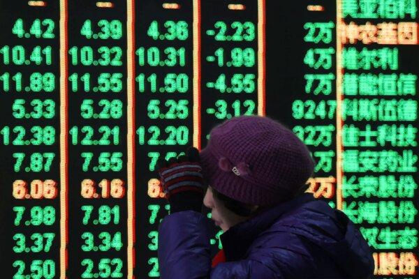 A woman reacts in front of an electronic screen displaying stock prices at a brokerage house in Hangzhou in east China's Zhejiang Province, on Feb. 5, 2024. (Chinatopix via AP)