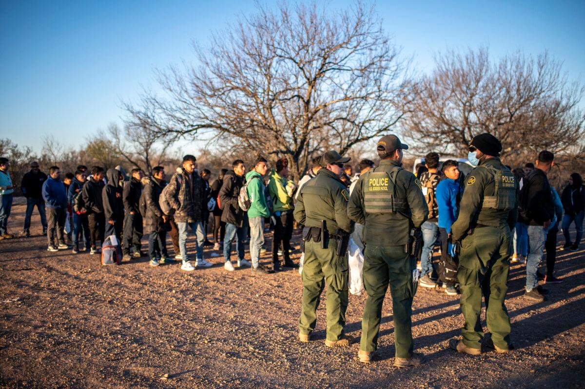 A group of illegal immigrants being processed by Border Patrol after crossing the river illegally near the highway outside Eagle Pass, Texas on Feb. 4, 2024. (Sergio Flores/AFP)