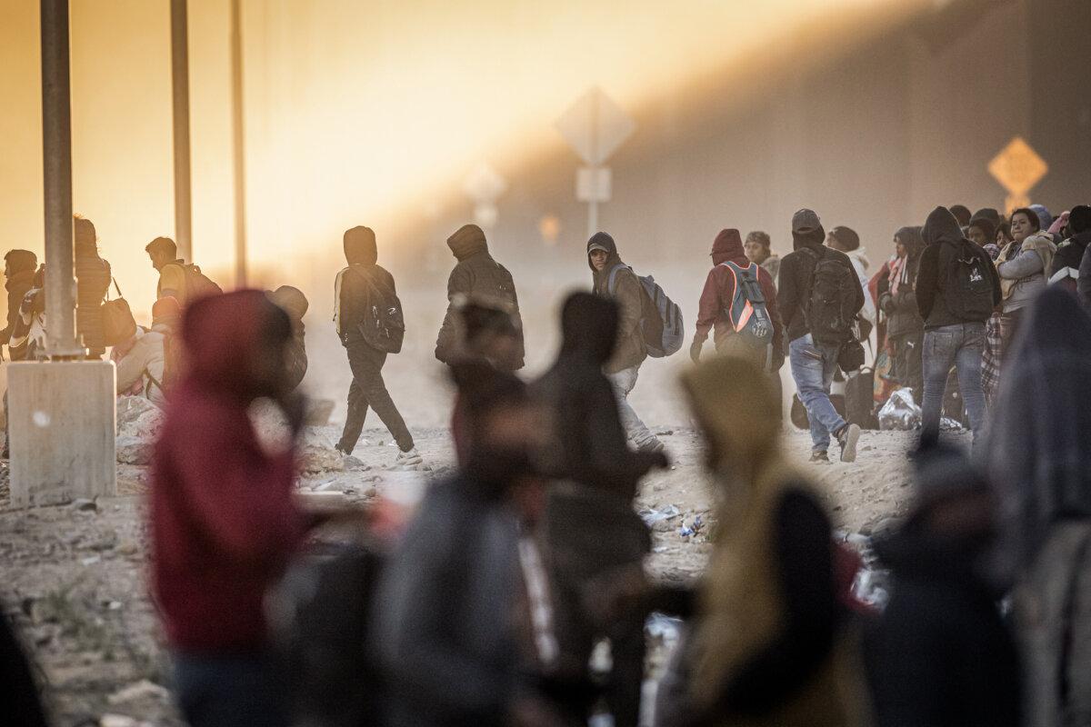 Illegal immigrants wait to be processed by U.S. border authorities after spending the night in the desert in Lukeville, Ariz., on Dec. 5, 2023. (John Moore/Getty Images)