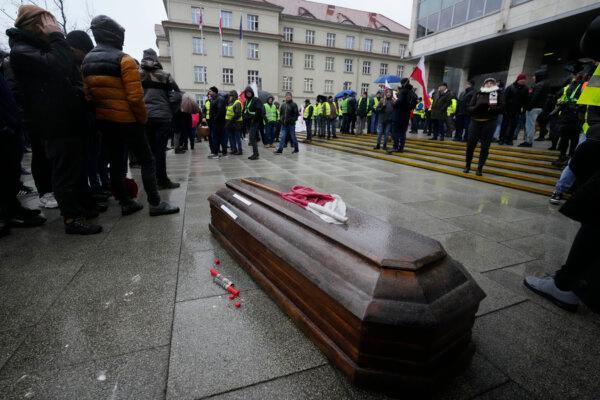 Polish farmers, angry at EU agrarian policy and cheap Ukraine produce imports which, they say, are undercutting their livelihoods, place a coffin to symbolize the death of Poland's agriculture, in front of the office of the regional governor, in Poznan, western Poland, Friday Feb. 9, 2024. (Czarek Sokolowski /AP Photo)