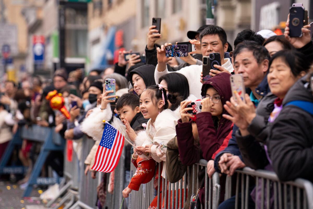 Spectators watch as Falun Gong practitioners attend a parade celebrating the Chinese New Year, in the Flushing neighborhood of Queens, N.Y., on Feb. 10, 2024. (Samira Bouaou/The Epoch Times)