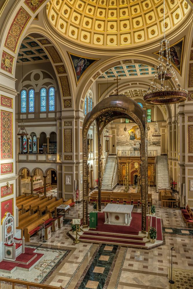 The bright interiors are made even more special by glistening tiles and stained glass windows that bring to life important stories of the Christian faith. Beyond the altar is a replica of the tomb of Jesus. (Guillermo Olaizola/Shutterstock)