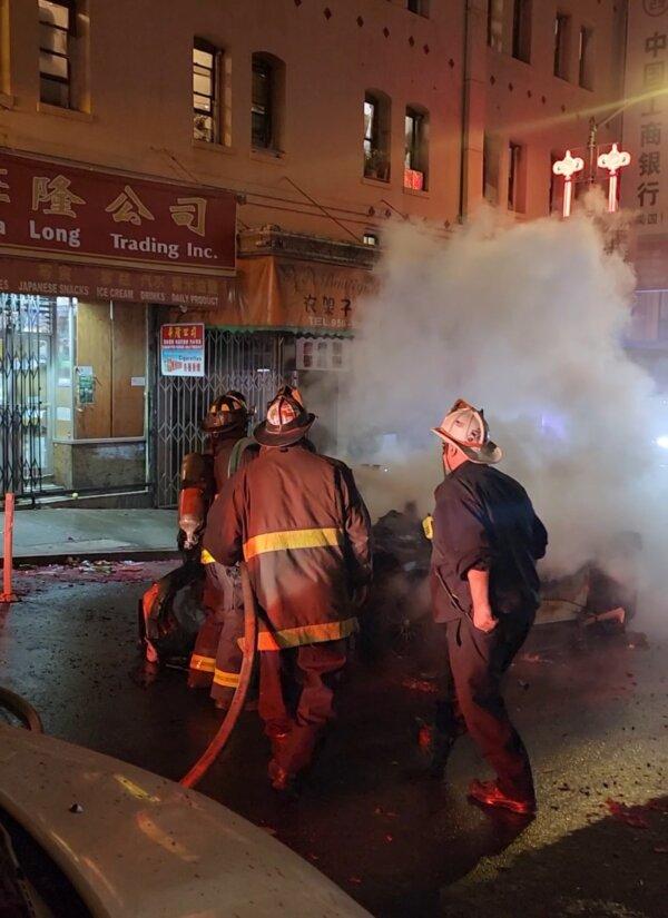 Firefighters put out a fire on a Waymo rider-only robotaxi that was surrounded by a mob and destroyed during Lunar New Year celebrations in the Chinatown neighborhood of San Francisco on Feb. 10, 2024. (Courtesy of Séraphine Hossenlopp)