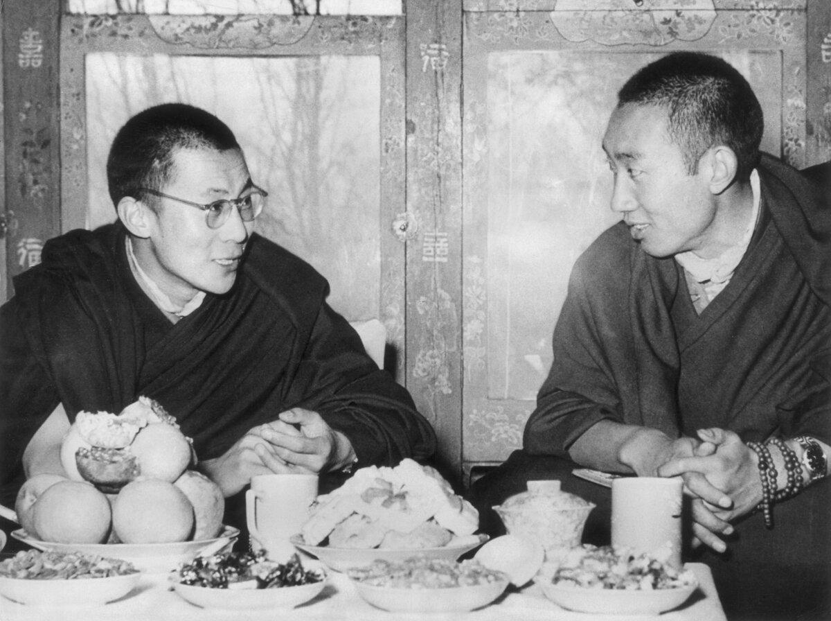 The Dalai Lama of Tibet (Tenzin Gyatso; L) and the Panchen Lama (second in rank as spiritual leader), seated and talking at a dining table in  Tibet on May 24, 1954. (Hulton Archive/Getty Images)
