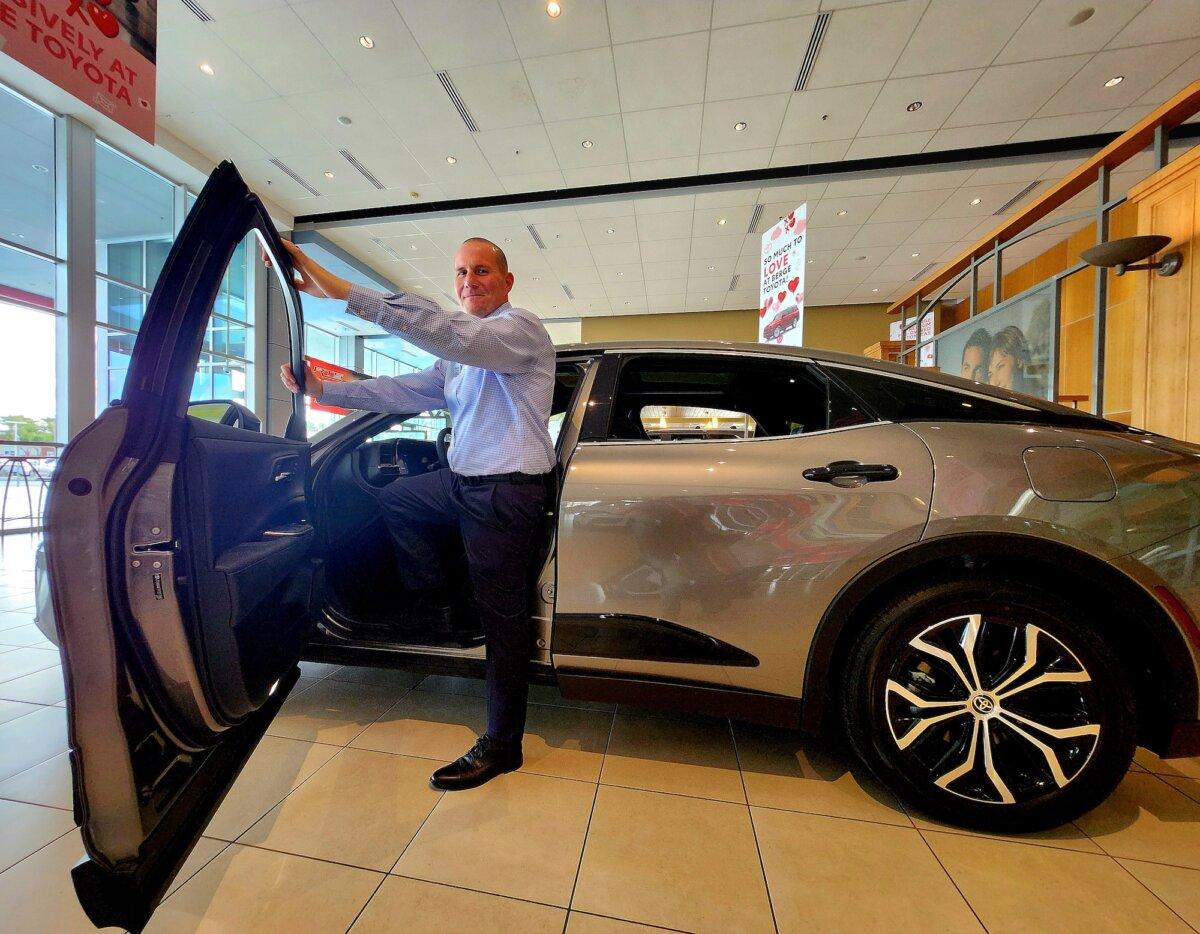 James Haas, used-car sales manager at Berge Toyota in Mesa, Ariz., stands in front of a traditional gas-powered vehicle on Feb. 1, 2024. (Allan Stein/The Epoch Times)