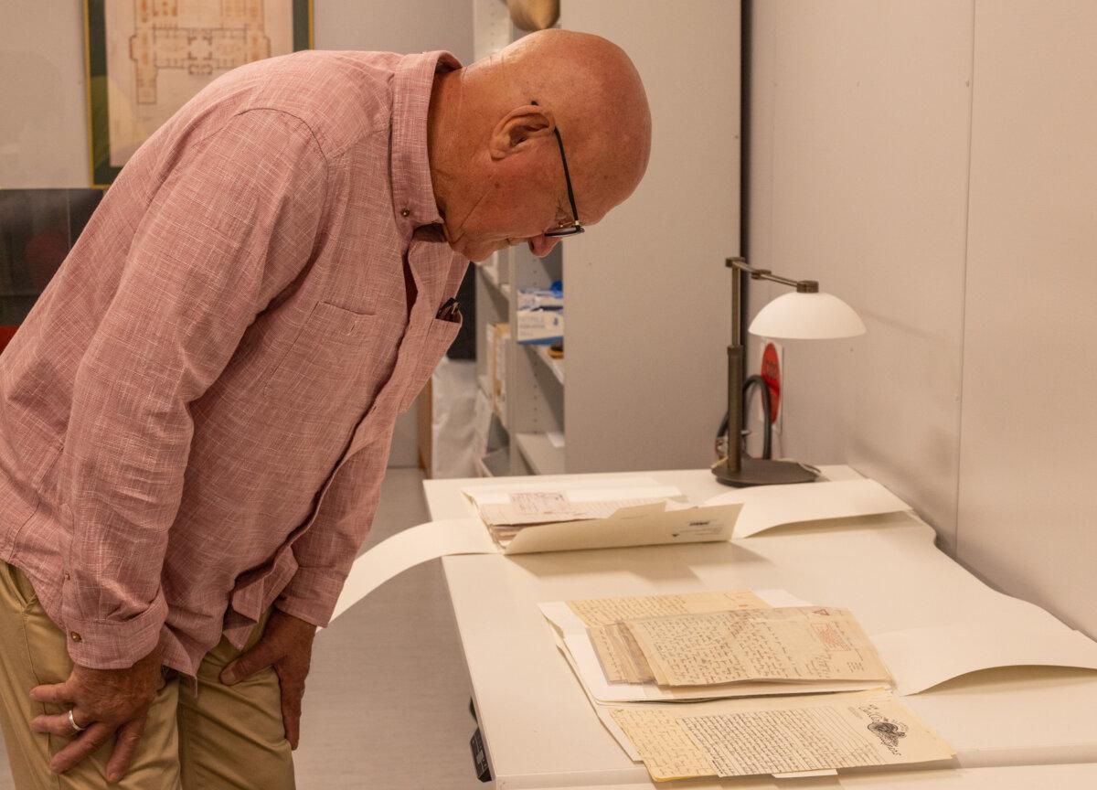 Peter Keshan inspects letters donated to the national collection by his mother Dorothy Keshan, at the Australian War Memorial in Canberra. (Courtesy of the Australian War Memorial)