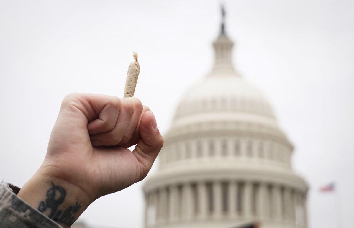 A pro-cannabis activist holds up a marijuana cigarette during a rally on Capitol Hill in Washington on April 24, 2017. (Mandel Ngan/AFP via Getty Images)