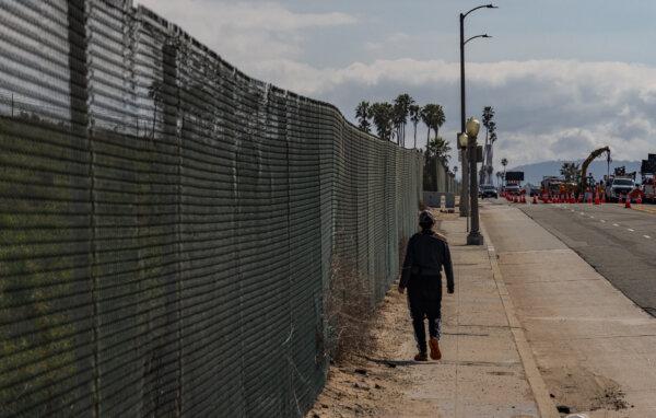 A woman walks along the edge of the former Surfridge neighborhood in Playa Del Rey on Feb. 14, 2024. (John Fredricks/The Epoch Times)