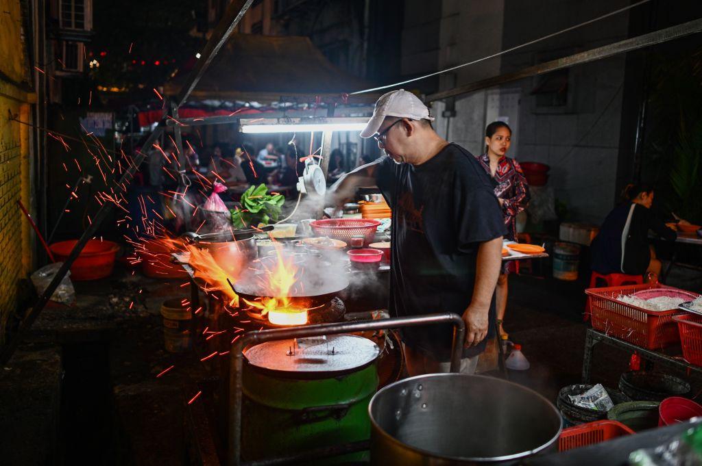 A man cooks on a roadside stall in Kuala Lumpur on Dec. 11, 2019. (Mohd Rasfan/AFP via Getty Images)