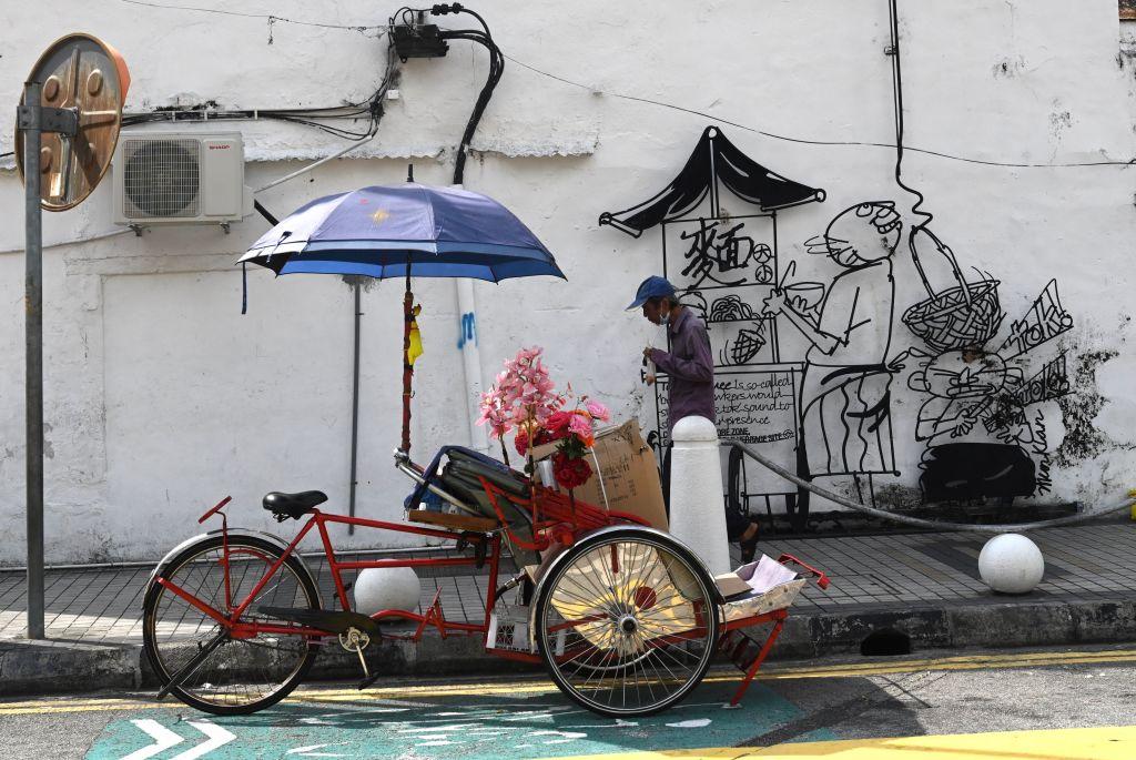 A trishaw driver waits for customers along a street in Penang, Malaysia on May 10, 2020. (Goh Chai Hin/AFP via Getty Images)