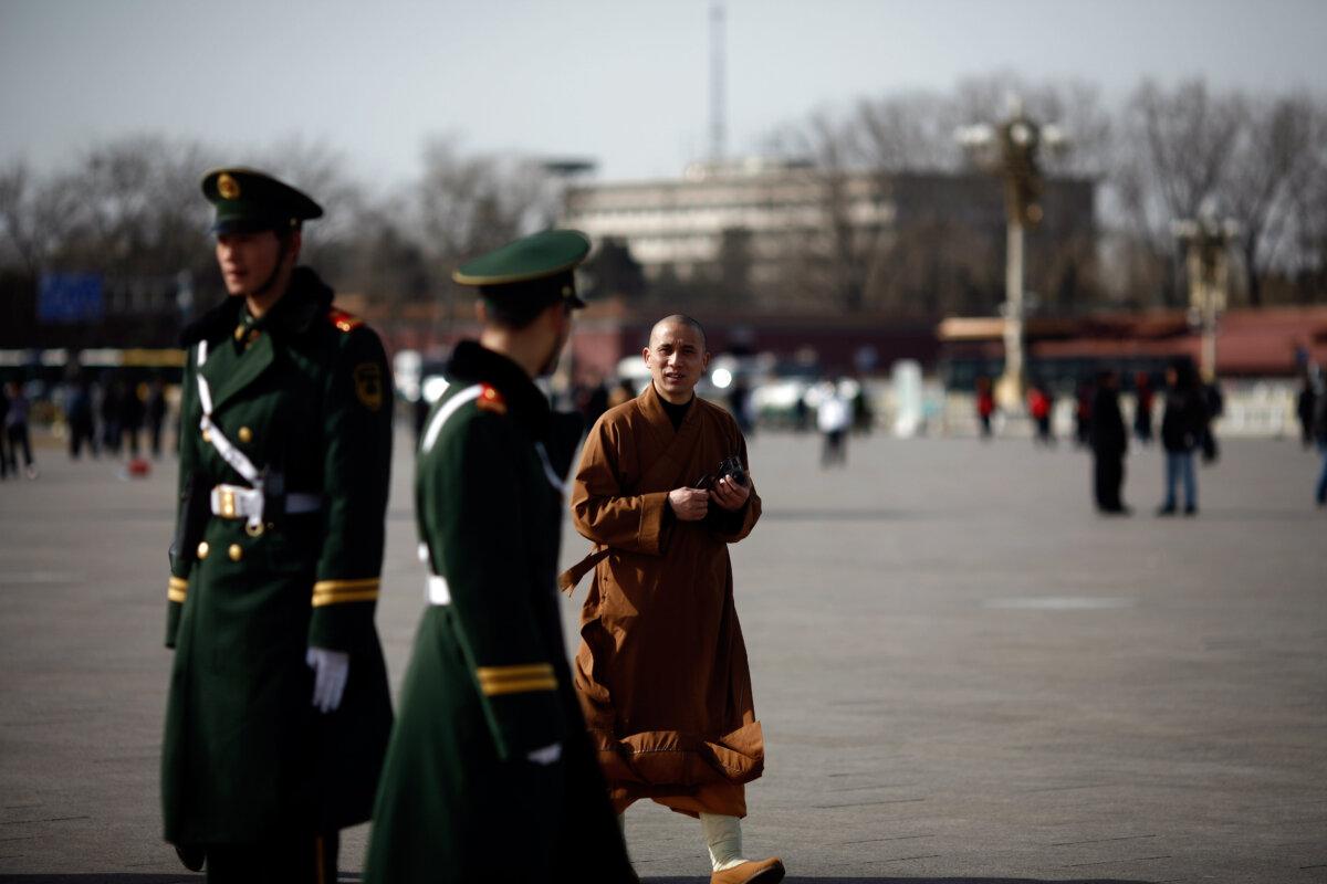 A Taoist monk walks past paramilitary police in Beijing on March 2, 2010. (Li Xin/AFP via Getty Images)