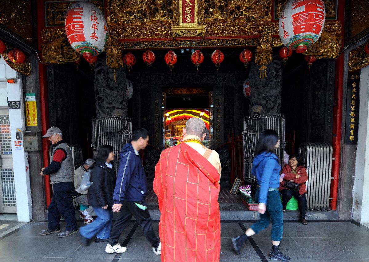 A Taoist monk offers prayers to passerbys outside a temple in Taipei on March 23, 2008. (Goh Chai Hin/AFP via Getty Images)