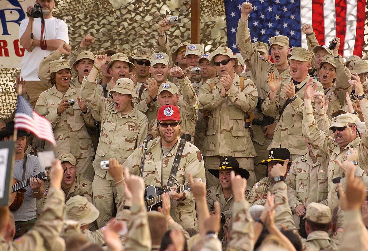 Toby Keith (C) plays during a United Service Organizations (USO) performance May 17, 2005 at Camp Victory in Baghdad, Iraq. (Mike Theiler/Getty Images)
