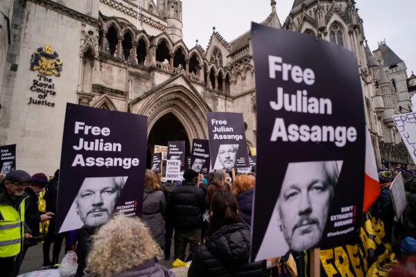 Demonstrators hold banners and placards outside the Royal Courts of Justice in London, on Feb. 20, 2024. (Alberto Pezzali/AP Photo)