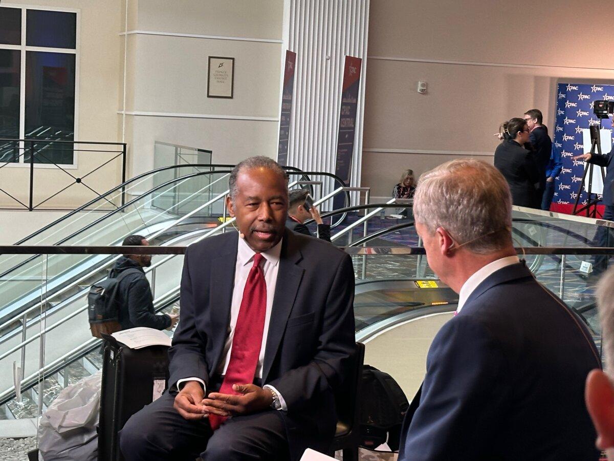 Former Housing and Urban Development Secretary Dr. Ben Carson talks with former British politician Nigel Farage at CPAC on Feb. 22, 2023. (Jackson Richman/Epoch Times)