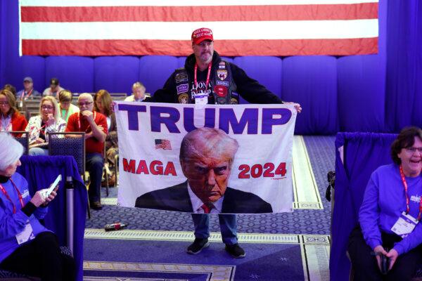 Scott Knuth holds up a flag with the face of Republican presidential candidate and former U.S. President Donald Trump during the Conservative Political Action Conference (CPAC) at Gaylord National Resort Hotel And Convention Center in National Harbor, Md., on Feb. 22, 2024 (Anna Moneymaker/Getty Images)