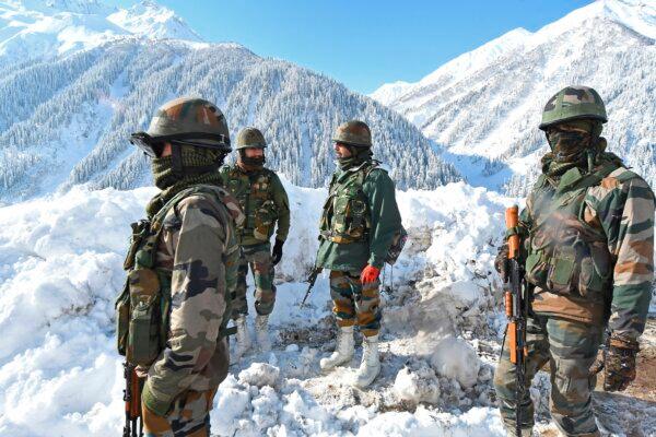 Indian army soldiers patrol a snow-covered road near Zojila mountain pass that connects Srinagar to the union territory of Ladakh, bordering China, on Feb. 28, 2021. (Tauseef Mustafa/AFP via Getty Images)