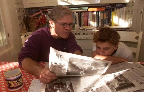 Rick Ridgeway, left, with his son Connor, reading a newspaper in an archival Los Angeles Times photo. (Bryan Chan/Los Angeles Times/TNS)