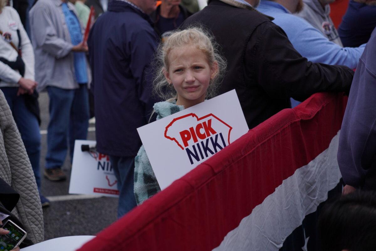 A girl holds a "Pick Nikki" sign before a Nikki Haley appearance in Moncks Corner, South Carolina, on Feb. 23, 2024. (Ivan Pentchoukov/The Epoch Times)