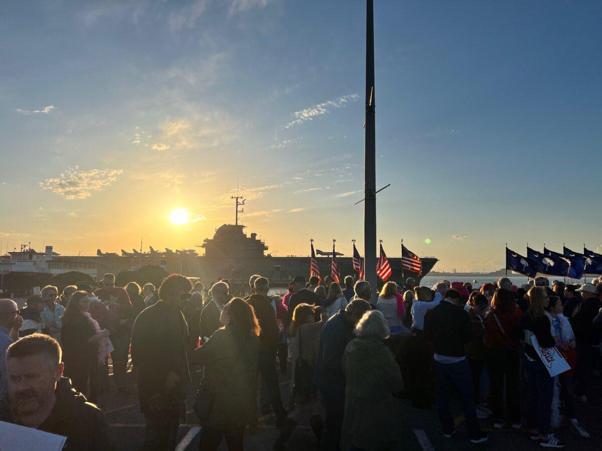 The sun sets toward the horizon as attendees at a Nikki Haley rally gather to the backdrop of USS Yorktown in Mt. Pleasant, S.C., on Feb. 23, 2024. (Ivan Pentchoukov/Epoch Times)