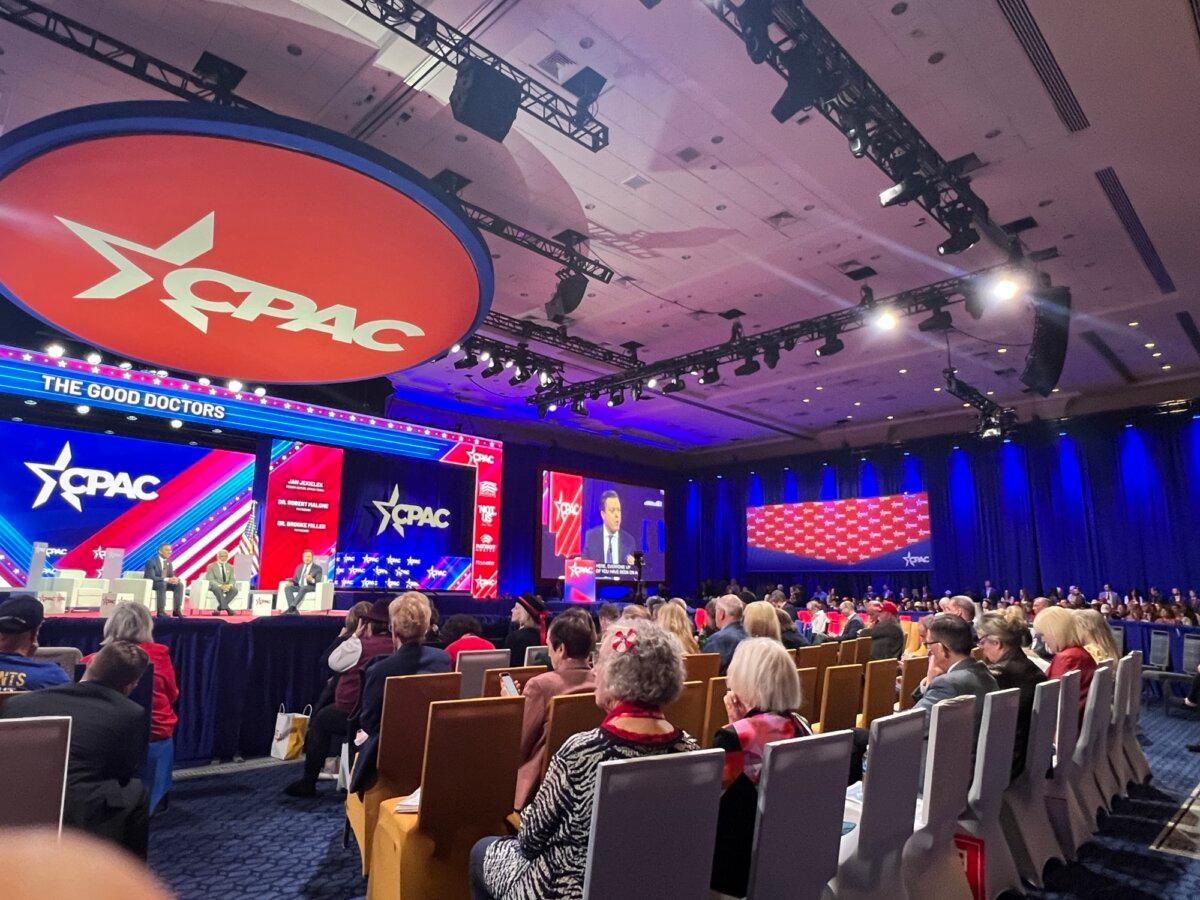 Attendees watch a discussion between Epoch Times' senior editor Jan Jekielek (R) with Dr. Robert Malone and Dr. Brooke Miller at CPAC in National Harbor, Md. on Feb. 24, 2024. (Janice Cheung/ The Epoch Times)