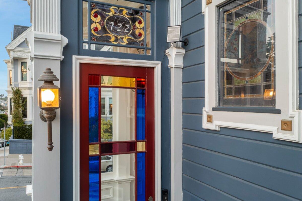 The front door of 722 Steiner Street was kept as close to the original as possible during renovations.  Stained glass allows light inside and offers privacy, while two larger mirrored panels reflect the street outside.  (Courtesy of Indigo Real Estate)