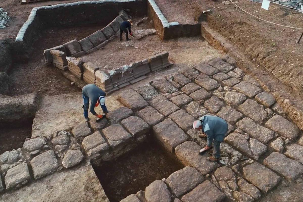 Archeologists brush clean the ancient stone pavement. (Courtesy of Emil Aladjem, Israel Antiquities Authority)