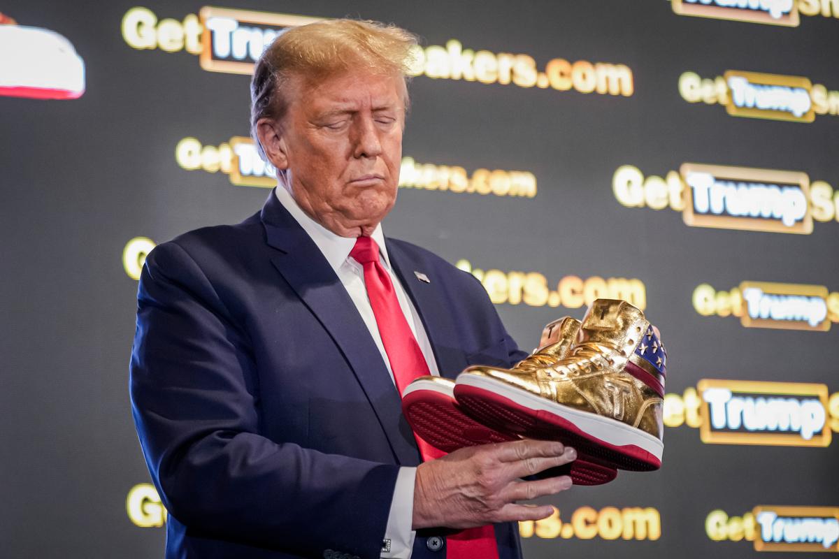 Former President Donald Trump holds gold Trump sneakers at SneakerCon in Philadelphia on Feb. 17, 2024. (Manuel Balce Ceneta/AP Photo)