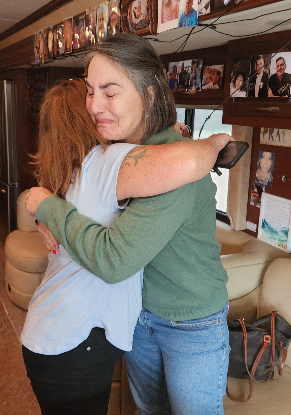 Lisa von Geldern (R) hugs Cheryl Baker during a scheduled visit of the Children's Health Defense tour bus in Tucson, Ariz., on Feb. 26, 2024. (Allan Stein/The Epoch Times)