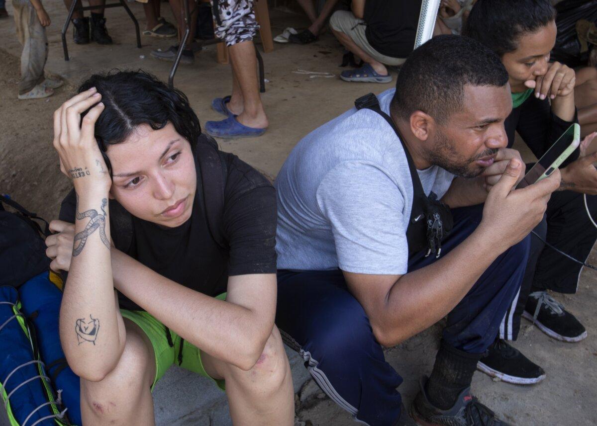 Fabiola Suarez from Venezuela rests at Bajo Chiquito in the Darien Gap after a 3-day trek from Colombia on Feb. 18, 2024. She said her destination is Denver, where her husband is waiting. (Bobby Sanchez for The Epoch Times)