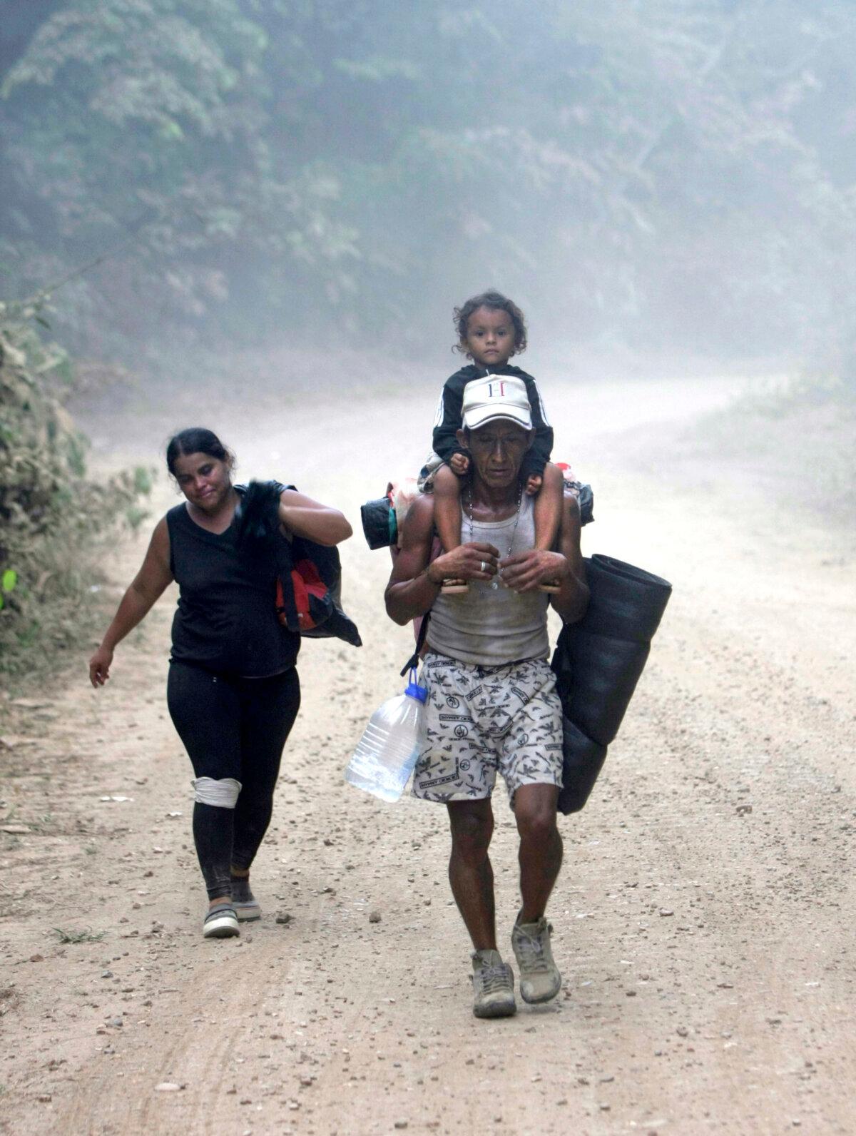 A Venezuelan family treks from Bajo Chiquito to Lajas Blancas on Feb. 18, 2024. The woman, who was limping as she walked, said her knee gave out. (Bobby Sanchez for The Epoch Times)