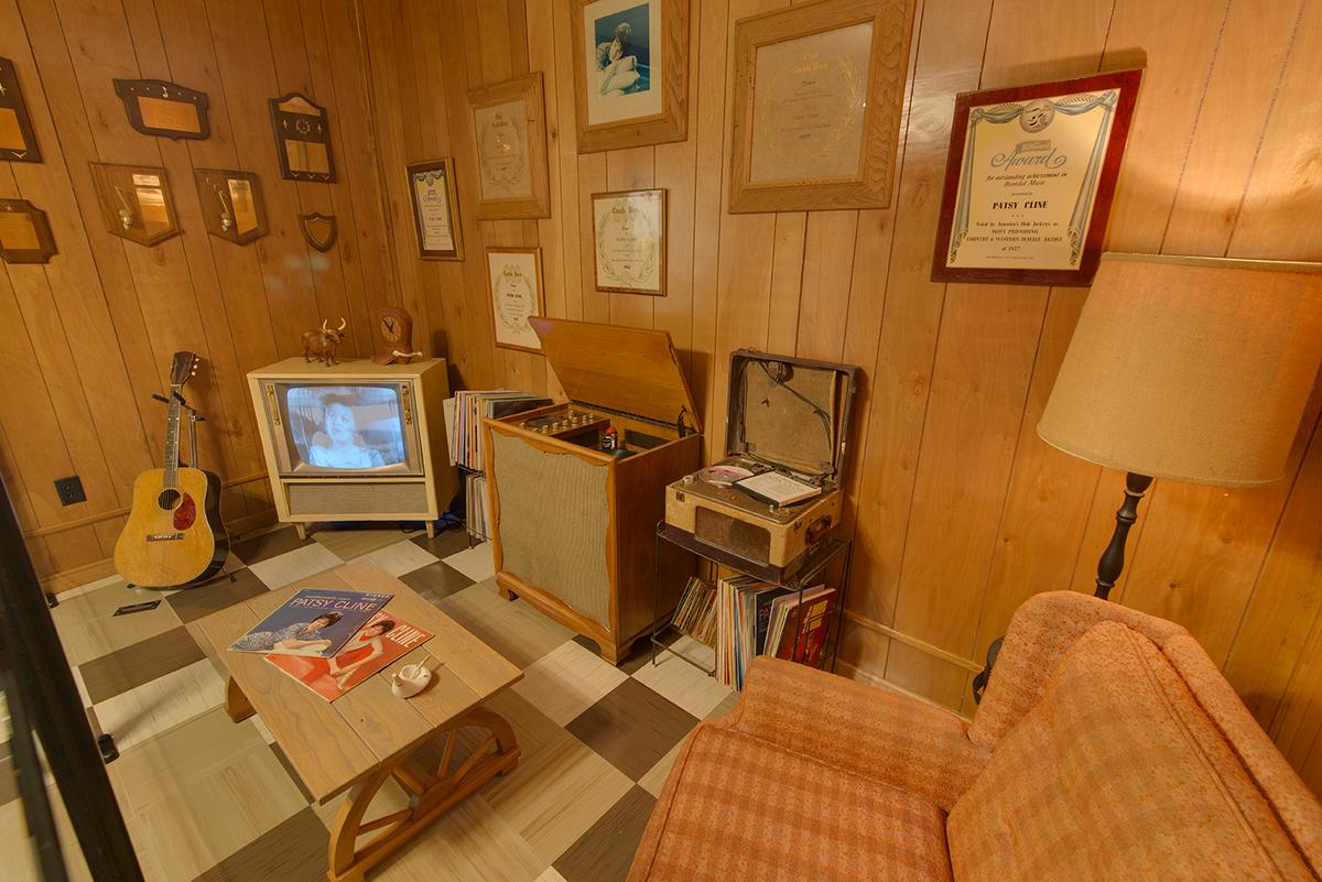 The vintage rec room includes a hi-fi stereo console, record player and vinyl LPs, and a vintage black-and-white television displaying Cline performances. (Courtesy of Patsy Cline Museum)