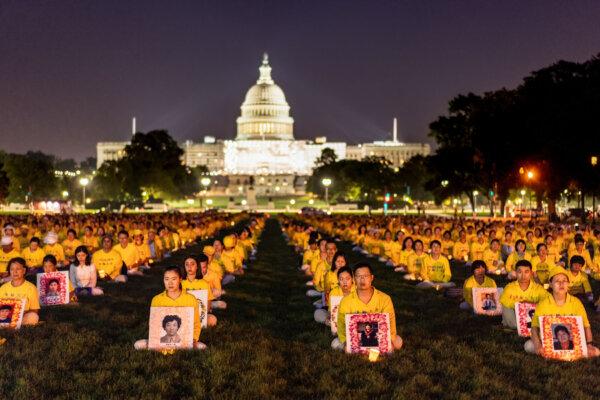 Falun Gong adherents take part in a candlelight vigil in memory of Falun Gong practitioners who passed away due to the CCP’s 24 years of persecution, at the National Mall in Washington on July 20, 2023. (Samira Bouaou/The Epoch Times)
