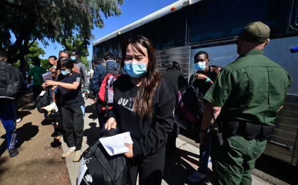 A U.S. Border Patrol officer watches as illegal immigrants from China and Africa get off a bus on arrival at a San Diego train station in San Diego on Oct. 10, 2023. (Frederic J. Brown/AFP via Getty Images)