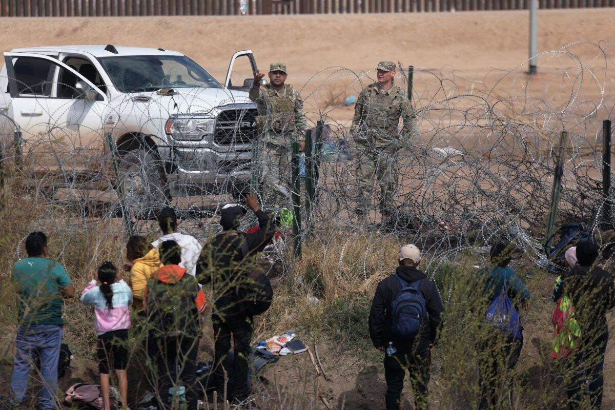 Texas National Guard agents prevent migrants from Venezuela from crossing a barbed wire fence to at the El Paso Sector Border after crossing the Rio Grande from Ciudad Juarez, Chihuahua State, Mexico, on Feb. 29, 2024. (Herika Martinez/AFP via Getty Images)