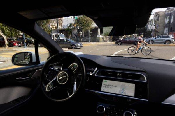 A cyclist passes in front of a Waymo autonomous vehicle in San Francisco on Nov. 17, 2023. (Jason Henry/AFP via Getty Images)