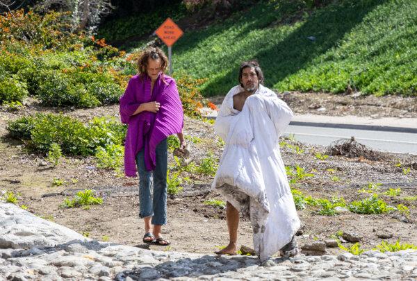 Homeless people walk off a freeway together in Los Angeles on March 4, 2024. (John Fredricks/The Epoch Times)