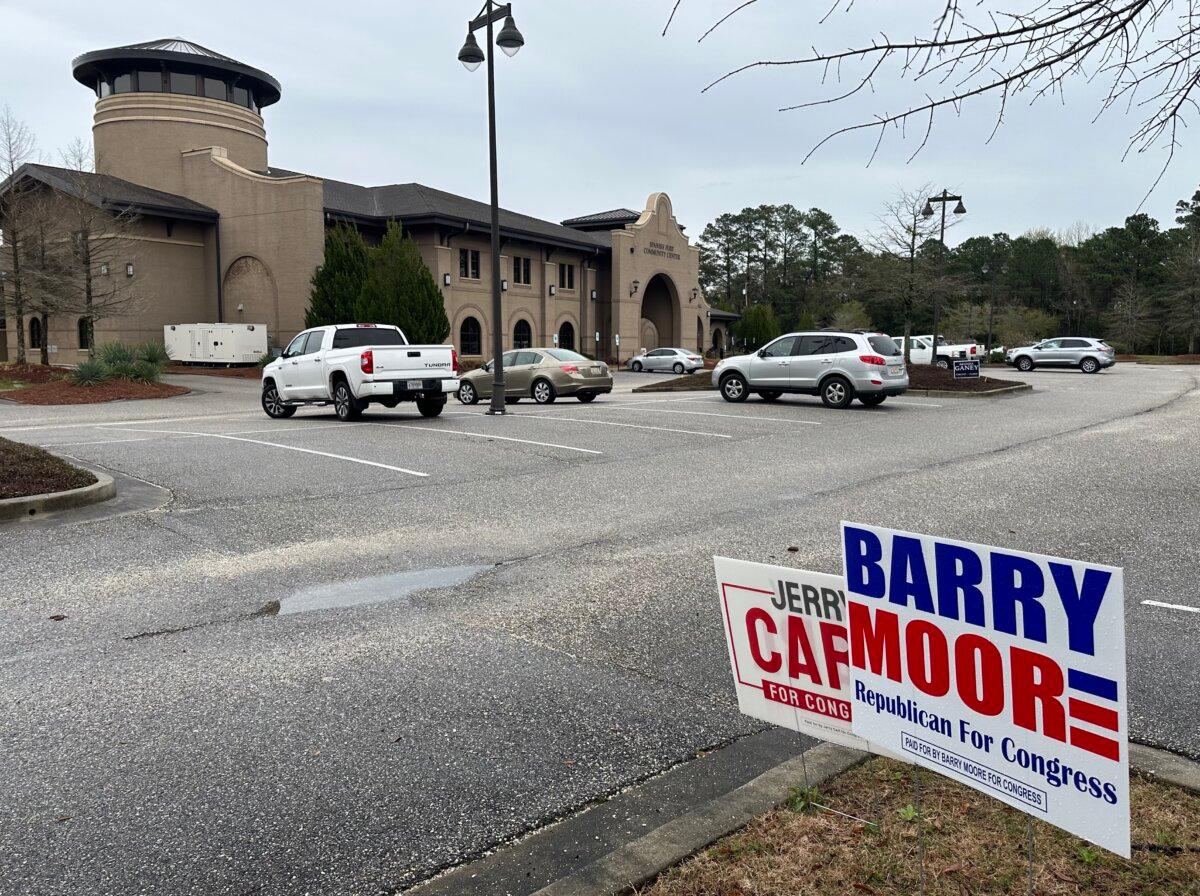 Competing signs for Rep. Jerry Carl (R-Ala.) and Rep. Barry Moore (R-Ala.) are posted outside the Spanish Fort Community Center in Spanish Fort, Alabama. (Austin Alonzo/The Epoch Times)