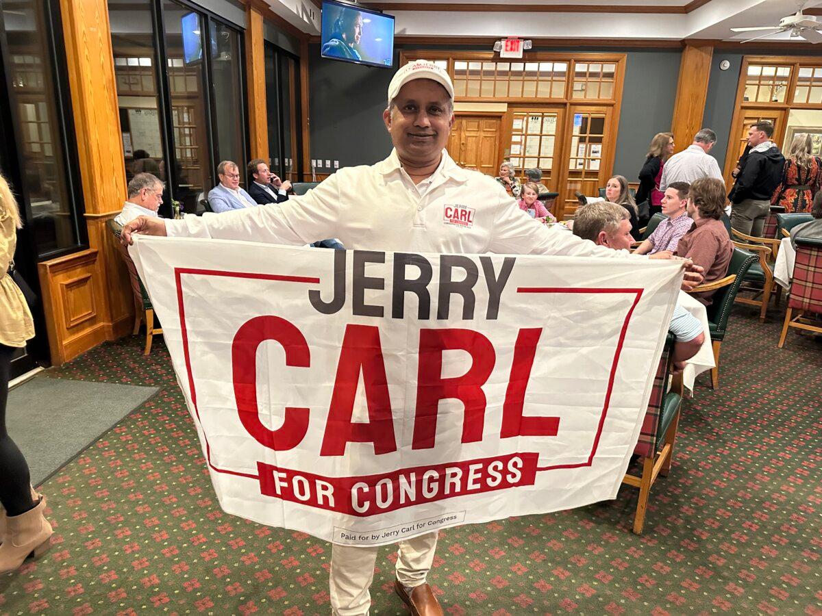 Mamun Siddiq, a member of the Mobile County Republican Executive Committee poses with his campaign materials at the Rep. Jerry Carl (R-Ala.) watch party at the TimberCreek Golf Club in Daphne, Alabama, on Tuesday, March 5, 2024. (Austin Alonzo/The Epoch Times)