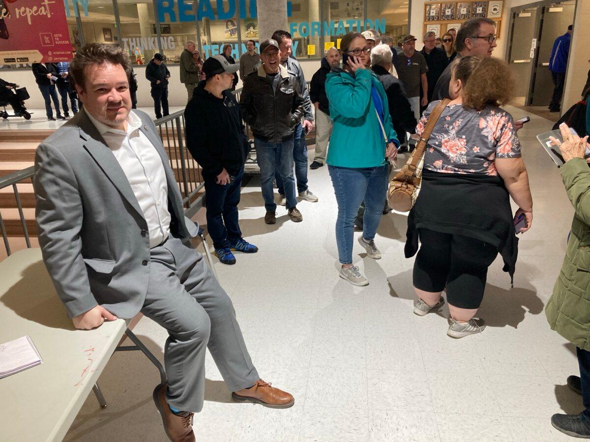 Utah state Rep. Matt MacPherson pauses from telling voters at a Hunter High School in West Valley City to be patient while waiting for a computer glitch to be resolved. (John Haughey/The Epoch Times)