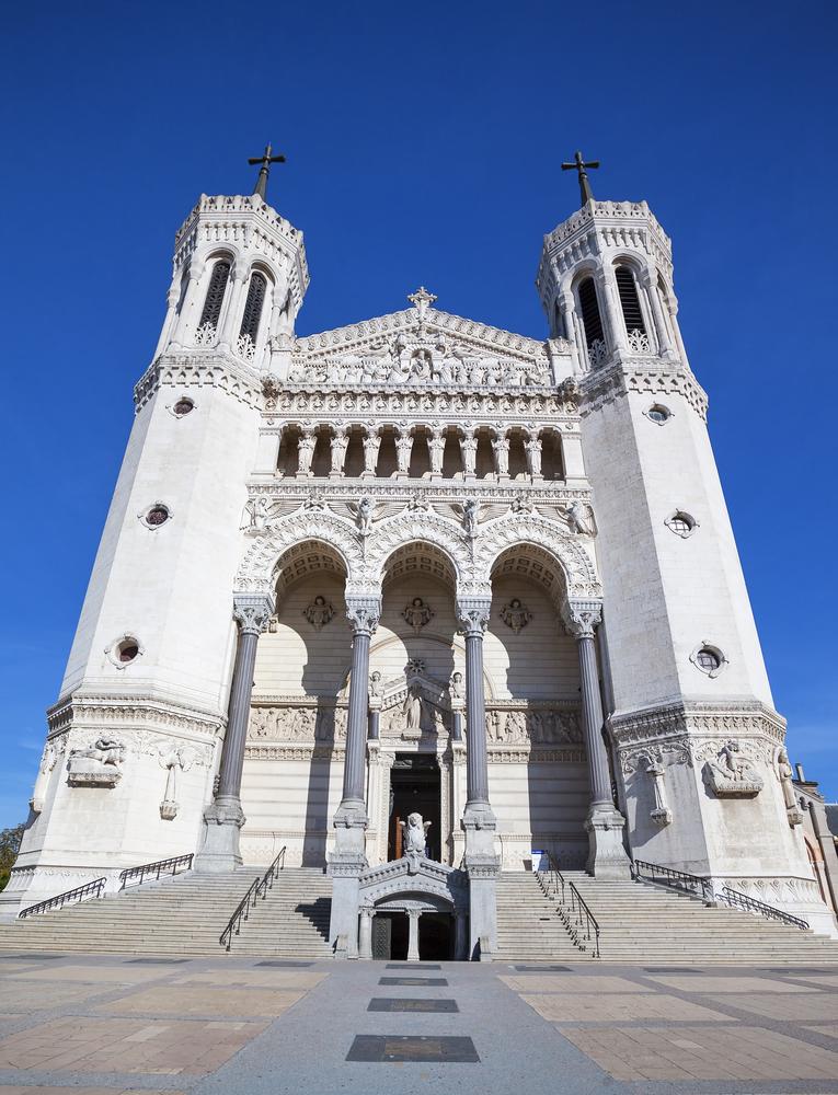 A white façade adorns the basilica. Two towers, Fortitude and Justice, face the square. The tower of Justice on the right depicts David and Goliath, and the left tower depicts the Judgement of Solomon. A triangular pediment links the towers, evoking the Virgin’s intercession in stopping the 1643 plague. Under the carved frieze, the upper gallery is supported by columns in the form of caryatids, or sculpted angels, sword in hand to reinforce the defensive aspect of the basilica. At the top of the steps, a bronze door represents Noah’s Ark and the Ark of the Covenant, and a winged lion statue, the emblem of Lyon, guards the entrance to the lower church, or crypt. (prochasson Frederic/Shutterstock)