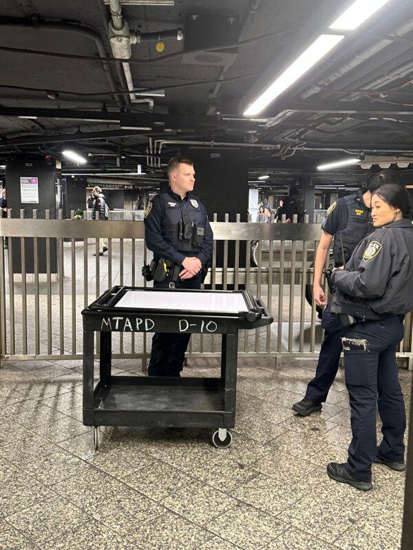 NYPD officers man a bag check station at the Grand Central subway station entrance on March 6, 2024. (Juliette Fairley/The Epoch Times)