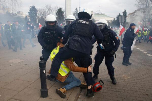 Police officers detain a man during the protests in Warsaw, Poland, on March 6, 2024. (Michal Dyjuk/AP Photo)