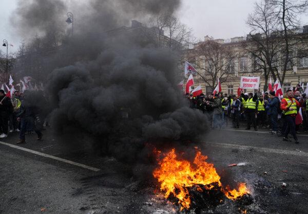 Fire burns in the street as farmers protest outside Polish Prime Minister Donald Tusk's office in Warsaw, Poland, on March 6, 2024. (Aleksandra Szmigiel/Reuters)
