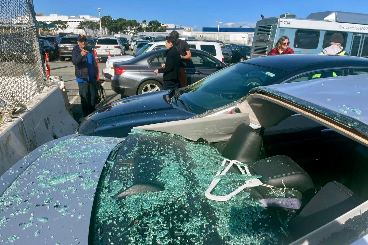 People view damaged cars in an on-airport employee parking lot after tire debris from a Boeing 777 landed on them at San Francisco International Airport on March 7, 2024. (Haven Daley/AP Photo)