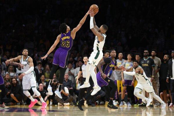 Spencer Dinwiddie (26) of the Los Angeles Lakers blocks a shot by Damian Lillard (0) of the Milwaukee Bucks during the final seconds of the second half of a game in Los Angeles on March 8, 2024. (Sean M. Haffey/Getty Images)