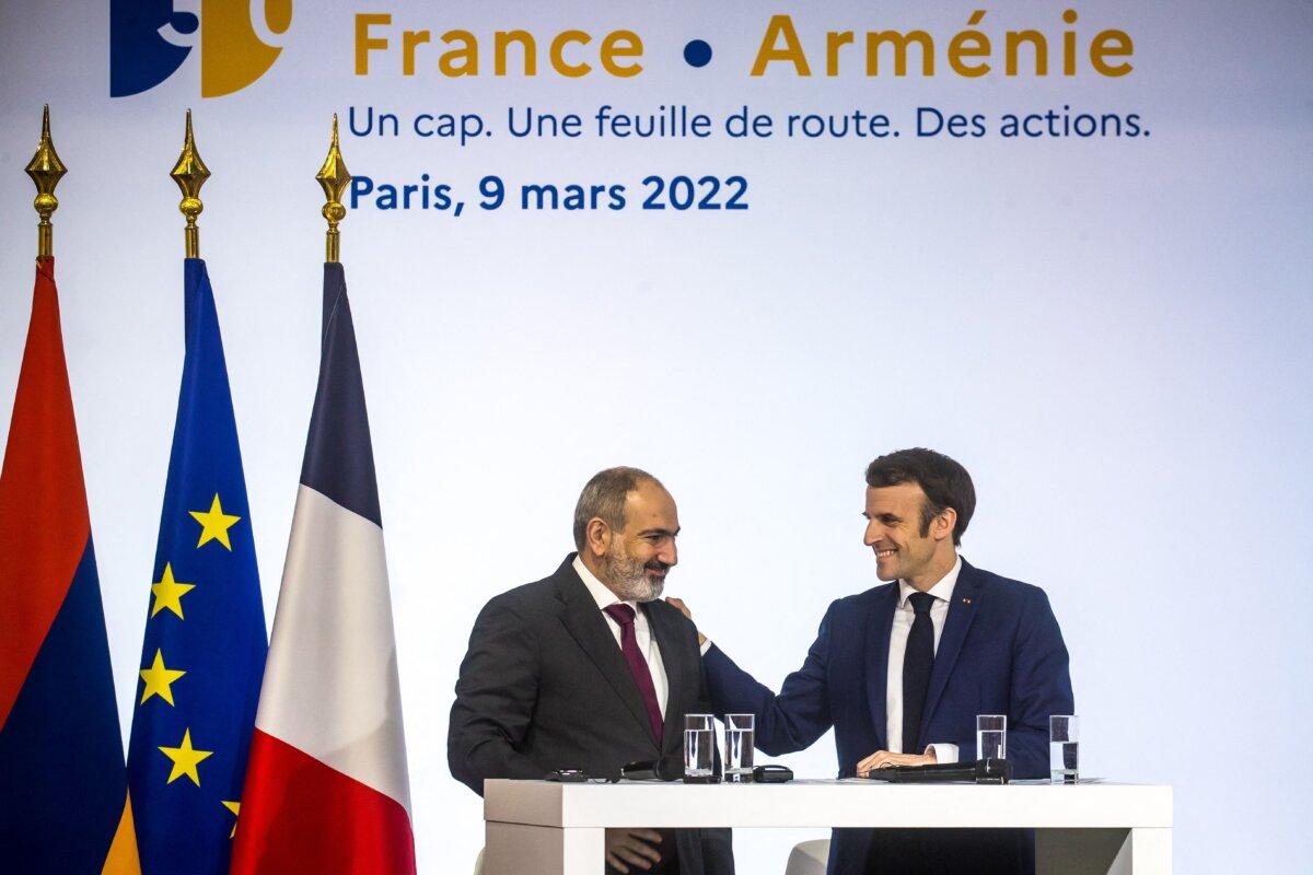 French President Emmanuel Macron (R) greets Armenian Prime Minister Nikol Pashinyan during a conference marking 30 years since the opening of diplomatic relations between France and Armenia, in Paris on March 9, 2022. (Christophe Petit Tesson/Pool/AFP via Getty Images)