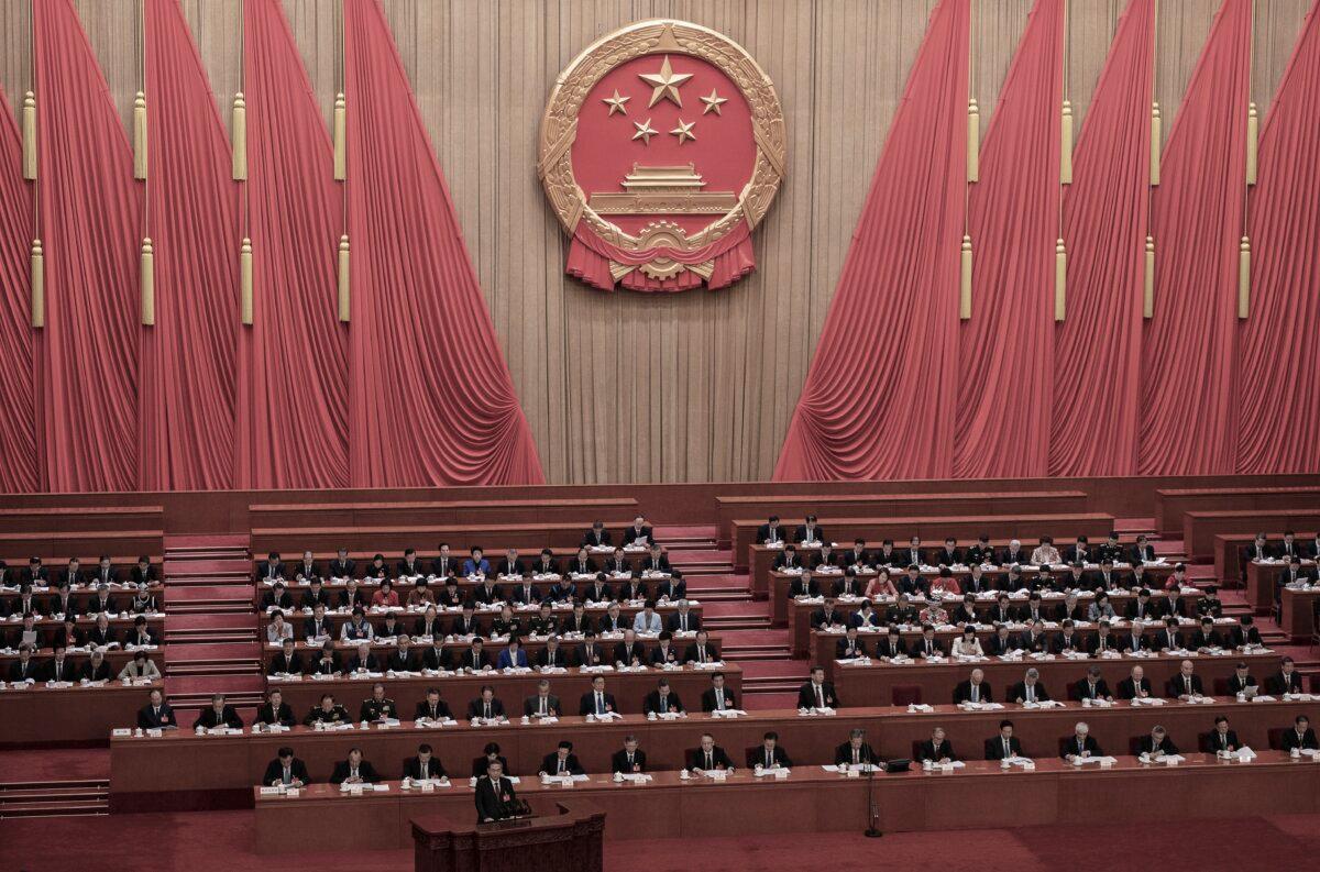 Chinese Premier Li Qiang (bottom L) stands at the podium during his speech at the opening of the NPC, or National People's Congress, at the Great Hall of the People on March 5, 2024 in Beijing, China. (Kevin Frayer/Getty Images)